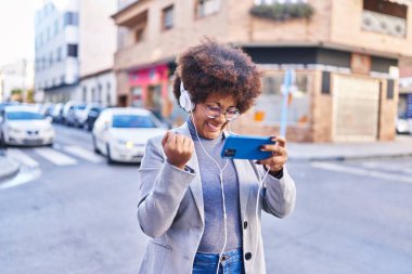 African american woman executive playing video game at street
