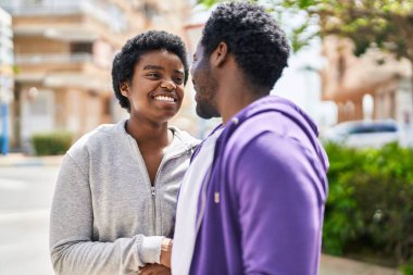 Afrika kökenli Amerikalı erkek ve kadın çift sokakta birlikte konuşuyorlar.