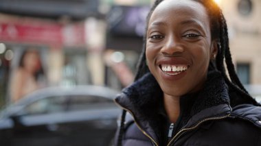 Sokakta kendine güvenen Afrikalı Amerikalı kadın gülümsüyor