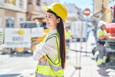 Young chinese woman architect smiling confident standing with arms crossed gesture at street