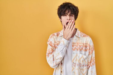 Gündelik tişört giyen genç adam ağzıyla esnemekten sıkıldı. Huzursuz ve uykulu.. 