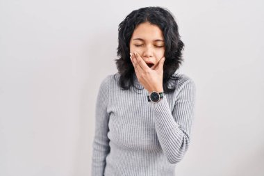 Tecrit edilmiş arka planda duran esnemekten sıkılmış koyu renk saçlı İspanyol kadın elleriyle ağzını kapatmaktan sıkılmış. Huzursuz ve uykulu.. 