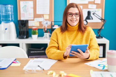 Young beautiful plus size woman business worker using touchpad working at office