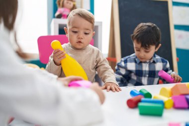 Anaokulunda elinde bovling lobutuyla oynayan sevimli çocuklar.