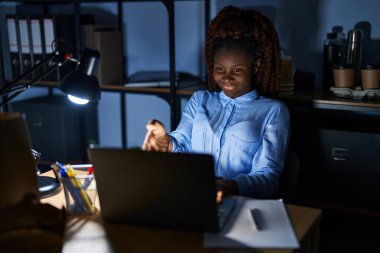 Geceleri ofiste çalışan Afrikalı bir kadın gülümseyerek selamlama ve hoş geldin demek için tokalaşıyor. başarılı iş. 