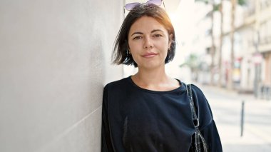 Sokakta ciddi bir ifadeyle duran genç, güzel İspanyol kadın.