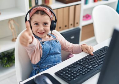 Sevimli İspanyol öğrenci sınıfta parmak hareketi yaparak bilgisayar kullanıyor.