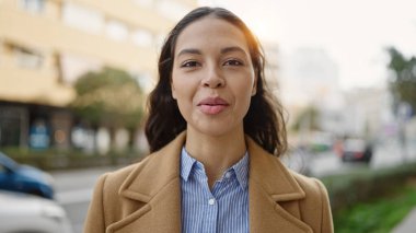 Sokakta ciddi bir ifadeyle duran genç, güzel İspanyol kadın.