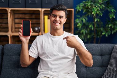 Akıllı telefonu tutan İspanyol adam boş ekranı göstererek mutlu ve gururlu bir kendini işaret ediyor. 