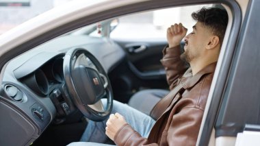 Genç bir Arap sokakta arabada dans ediyor.