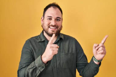 Ayrıca sarı arka planda duran, gülümseyen ve kameraya bakan sakallı, iki eli ve parmakları yanda olan İspanyol bir adam.. 