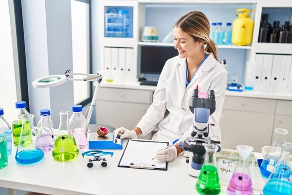 Young Hispanic Woman Scientist Weighing Gemstone Writing Report Laboratory —  Fotos de Stock