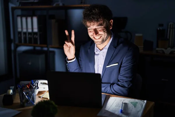 Jovem Hispânico Trabalhando Escritório Noite Sorrindo Com Rosto Feliz Piscando — Fotografia de Stock