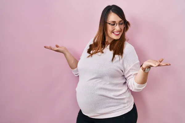 분홍색 위에서 벌리고 웃으며 임신부 발표와 광고를 비교하고 균형을 — 스톡 사진