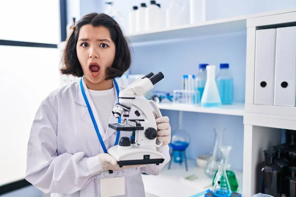 Laboratuvarda Çalışan Genç Latin Bir Kadın Mikroskop Tutuyor Şok Olmuş — Stok fotoğraf