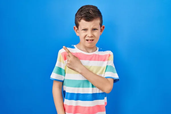 Mavi Arka Planda Dikilen Genç Beyaz Çocuk Işaret Parmağıyla Endişeli — Stok fotoğraf