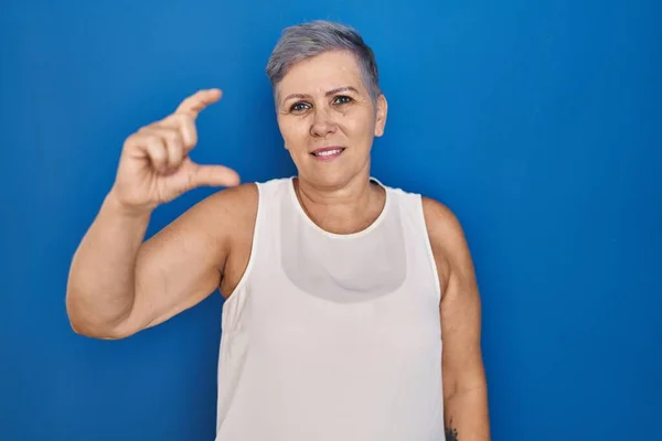 Orta Yaşlı Beyaz Bir Kadın Mavi Arka Planda Duruyor Gülümsüyor — Stok fotoğraf