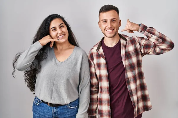 Young Hispanic Couple Standing White Background Smiling Doing Phone Gesture — Stock Photo, Image