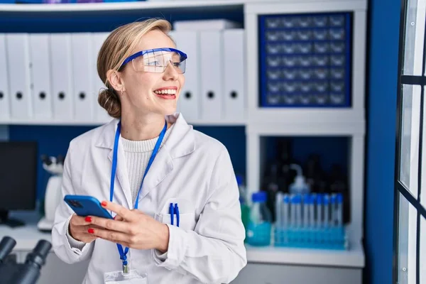 Young Blonde Woman Scientist Smiling Confident Using Smartphone Laboratory —  Fotos de Stock