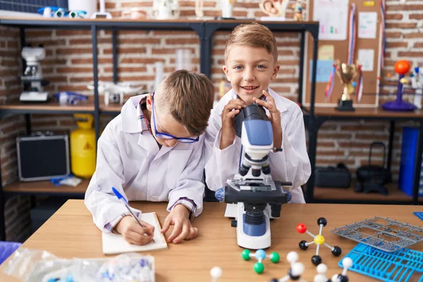 Roztomilí Chlapci Studenti Pomocí Mikroskopu Psaní Poznámek Laboratoři Učebny — Stock fotografie