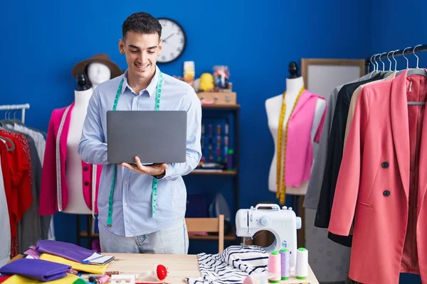 Young Hispanic Man Tailor Smiling Confident Using Laptop Sewing Studio — Stockfoto