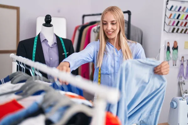 Young Blonde Woman Tailor Smiling Confident Holding Clothes Rack Tailor — Stockfoto