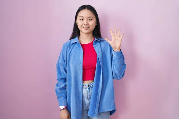 Молодая Азиатка Стоящая Розовом Фоне Показывающая Пальцами Номер Пять Улыбаясь — стоковое фото