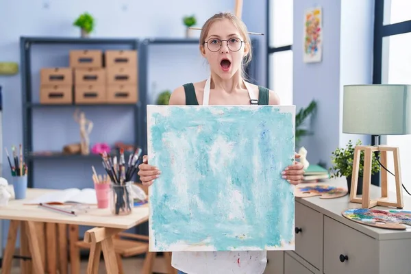 Young Caucasian Woman Holding Canvas Art Studio Afraid Shocked Surprise — Stock Photo, Image