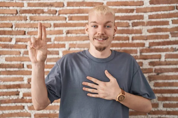 Young Caucasian Man Standing Bricks Wall Smiling Swearing Hand Chest — Stock Photo, Image