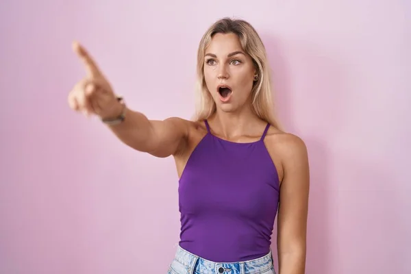 Young Blonde Woman Standing Pink Background Pointing Finger Surprised Ahead — Photo