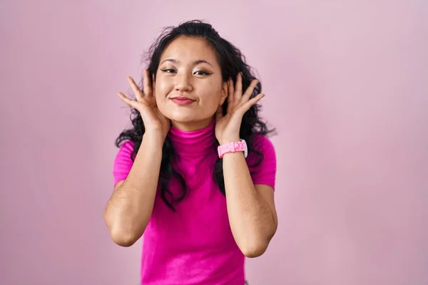 분홍색 양손으로 듣고자 아시아 여자는 이야기를 — 스톡 사진