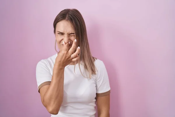 Blonde Caucasian Woman Standing Pink Background Smelling Something Stinky Disgusting — Stok fotoğraf