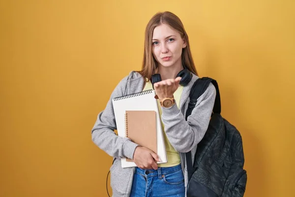 Młoda Kaukaska Kobieta Studenckim Plecaku Trzymająca Książki Patrząc Kamerę Dmuchająca — Zdjęcie stockowe