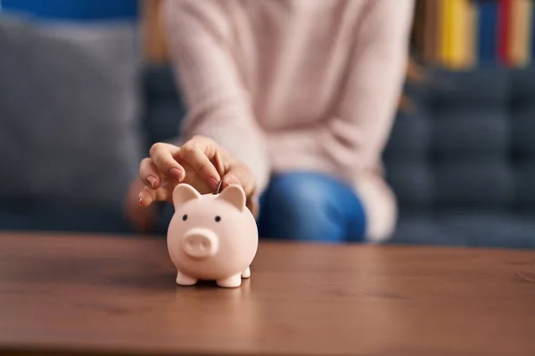 Young Woman Inserting Coin Piggy Bank Home —  Fotos de Stock