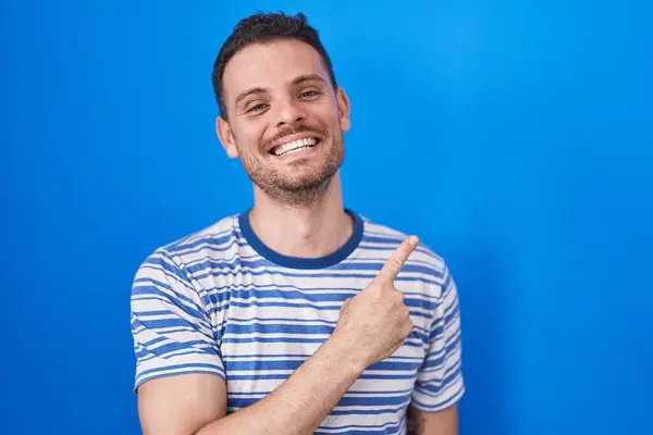 Jovem Hispânico Sobre Fundo Azul Alegre Com Sorriso Rosto Apontando — Fotografia de Stock