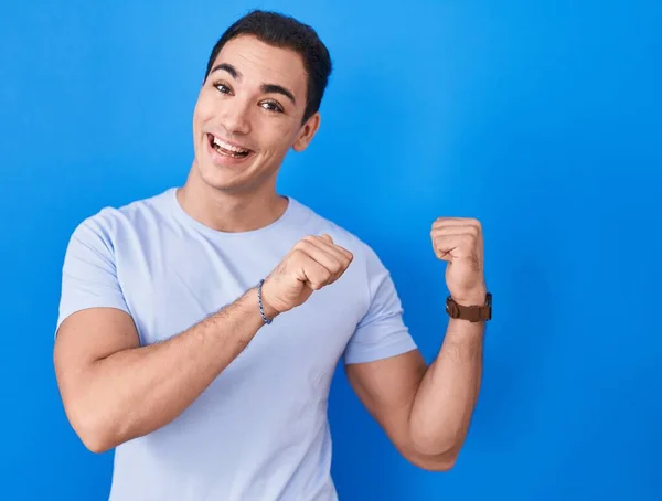 Young Hispanic Man Standing Blue Background Pointing Back Hand Thumbs — Stockfoto