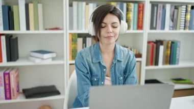 Genç beyaz kız öğrenci gülümsüyor. Üniversite sınıfında kendine güvenen bir video var.