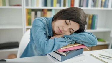 Üniversite sınıfında kafa kafaya uyuyan beyaz bir kız öğrenci.