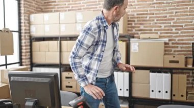 Orta yaşlı bir iş adamı ofiste bilgisayar kontrol paketi kullanıyor.