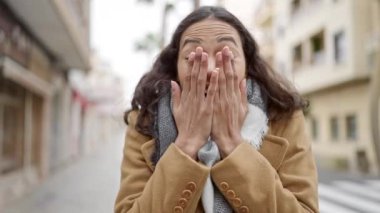 Genç, güzel, İspanyol bir kadın sokakta hazırlıksız bekliyor.