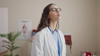 Genç, güzel İspanyol kadın doktor klinikte ciddi bir ifadeyle dikiliyor.