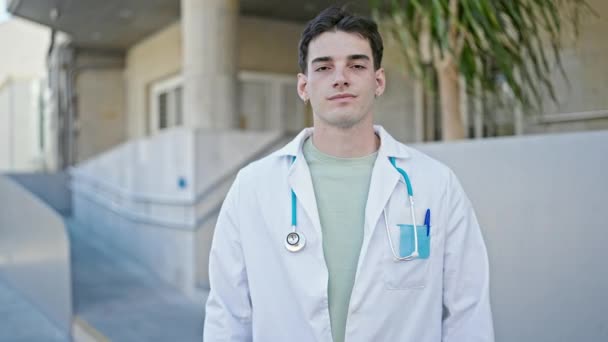Jonge Spaanse Man Dokter Staat Met Armen Gekruist Gebaar Houden — Stockvideo