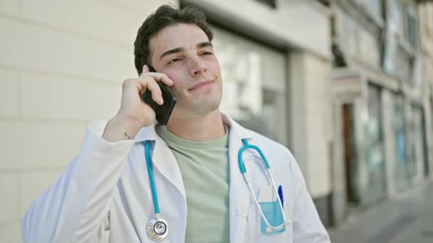 Młody Latynoski Mężczyzna Lekarz Uśmiecha Się Pewnie Rozmawiając Smartfonie Szpitalu — Wideo stockowe