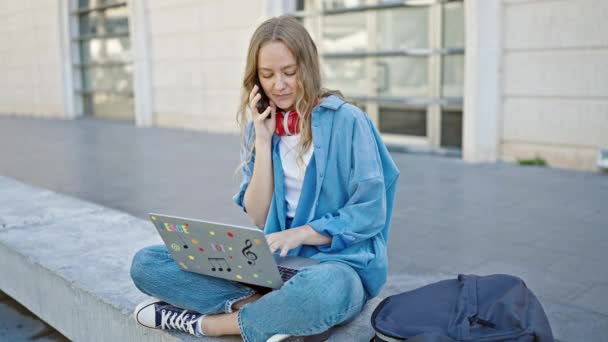 Jovem Loira Estudante Usando Laptop Falando Smartphone Universidade — Vídeo de Stock