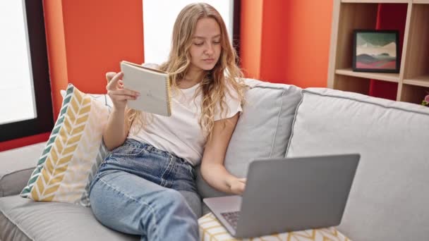 Junge Blonde Frau Schreibt Laptop Hause Auf Notizbuch — Stockvideo
