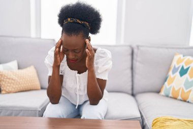 Afrikalı Amerikalı kadın evdeki kanepede otururken strese girdi.