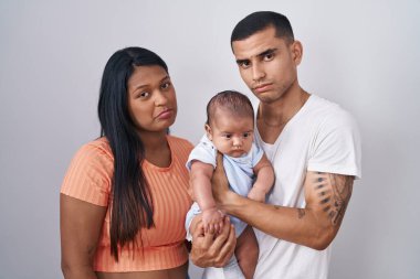 Çocuklu İspanyol bir çift, izole bir arka planda depresif ve endişeli bir şekilde ayakta duruyor. Kızgın ve korkmuş bir şekilde ağlıyorlar. hüzünlü ifade. 