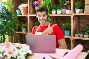 Çiçekçide çalışan genç İspanyol bir adam. Video çekiyor. Gülümsüyor, gülümsüyor. 