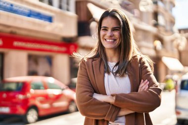 Sokakta kollarını kavuşturmuş genç, güzel İspanyol bir kadın.