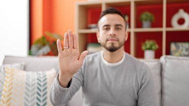 İspanyol adam evde el hareketlerini durduruyor.